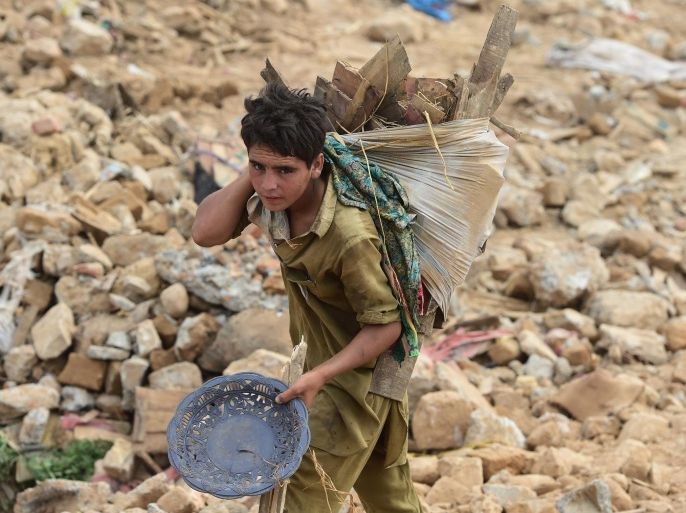 To go with AFP story 'Pakistan-housing-urban-planning-social' by Issam AHMEDIn this photograph taken on July 31, 2015, a Pakistani child shifts house hold items during an operation to demolish their poverty-stricken neighbourhood in Islamabad. With no water supply, electricity or sewage, the 2,000 homes that formed the 'Afghan Basti' slum in Islamabad have long stood in stark contrast to the rest of Pakistan's green and largely pristine capital. Situated on the edge of the city, the neighbourhood is now at the heart of a battle over housing rights for the poor versus a drive by city authorities to get rid of 'illegal' settlements. AFP PHOTO / Farooq NAEEM