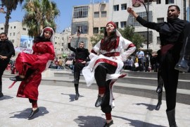 RAMALLAH, WEST BANK - JULY 25: Palestinians dance in traditional Palestinian clothing during a protest in Ramallah, West Bank on July 25, 2015. Hundreds of Palestinians marched in front of Al-Bire Cultural Centre in the city of Ramallah in protest at photographs of Israeli models and stewardesses in their traditional costume 'giving the impression that this costume belongs to the Jews'.