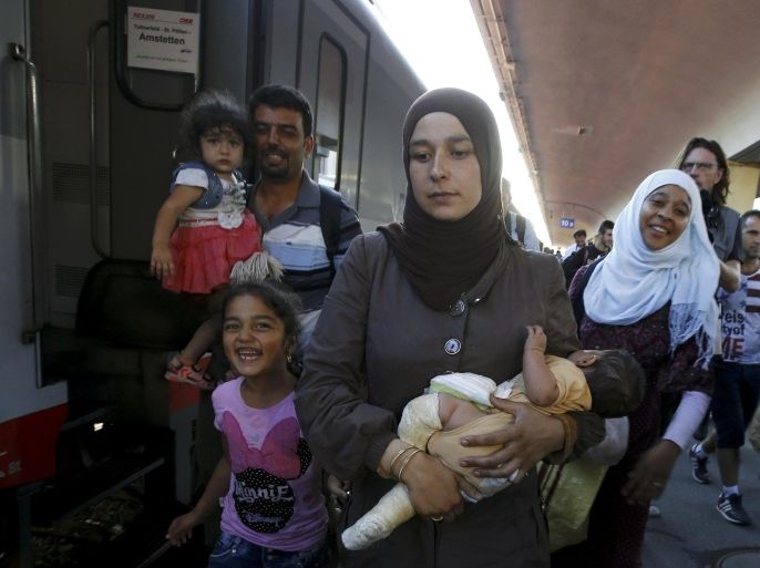 Travellers believed to be migrants leave a train coming from Hungary at the railway station in Vienna, Austria, August 31, 2015. Austrian authorities toughened controls along the country's eastern borders on Monday, stopping hundreds of refugees and arresting five traffickers in a clampdown that followed last week's gruesome discovery of 71 dead migrants in a truck. REUTERS/Leonhard Foeger