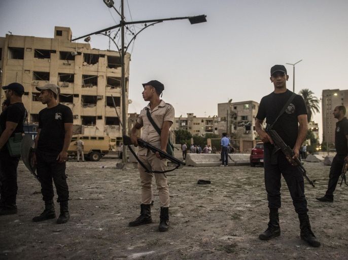 Egyptian riot policemen stand in front of the damaged national security building in northern Cairo's district of Shubra on August 20, 2015. A car bomb wounded six Egyptian policemen as it exploded in front of a police building, the interior ministry said, the latest in a wave of militant attacks that has rocked Egypt. AFP PHOTO / KHALED DESOUKI