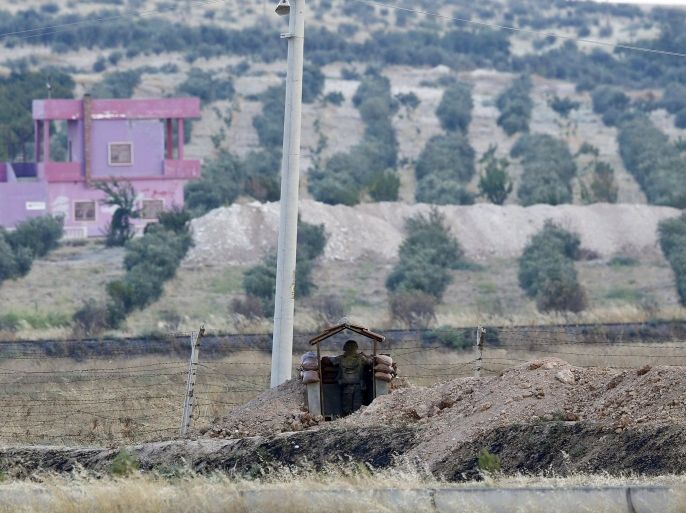 A Turkish soldier stands guard at the Turkish-Syrian border in Karkamis, bordering with the Islamic State-held Syrian town of Jarablus, in Gaziantep province, Turkey, August 1, 2015. Karkamis is a Turkish town of 10,500 people that sits directly opposite the border post. Shut for more than a year, the military sealed the crossing with a breeze block wall a few months ago. Behind it, just inside Syria, the black flag of Islamic State flaps in the breeze. Karkamis lies on the northeastern edge of a rectangle of Syrian territory some 80 km (50 miles) long, controlled by the radical Islamists. The United States and Turkey hope that by sweeping Islamic State from this border zone, they can deprive it of a smuggling route which has seen its ranks swollen with foreign fighters and its coffers boosted by illicit trade. Picture taken August 1, 2015. REUTERS/Murad Sezer
