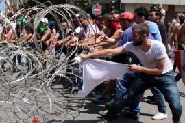 Lebanese activists try to remove barbed wire blocking the entrance to the Lebanese Government Palace during a protest against the ongoing garbage crisis, downtown Beirut, Lebanon, 23 August 2015. According to local reports, Lebanese citizens gathered to protest the government's ongoing inability to find a solution to the country's ongoing garbage crisis, which has left streets overflowing with garbage, due in large part to graft associated with the awarding of contracts to private companies linked to the Government to operate collections.