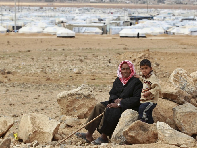 لاجئ سوري مسن مع حفيده في مخيم الزعتري بالأردن