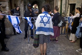 Israeli border police stand guard as a right-wing Jewish girl from the 'Students for the Temple Mount' movement wraps herself with an Israeli flag, against the shouts of protesting Palestinian muslims (not in frame), at the entrance to the Al-Aqsa mosque compound in the Old city of Jerusalem, Israel, 09 August 2015. Tension escalates at the al-Aqsa compound as more Jewish right-wing extremists are trying to pray inside the compound. The area houses the mosque, considered the third-holiest site in Islam, but it is also the site of the ruins of the biblical Jewish temple and is the most sacred site in Judaism.