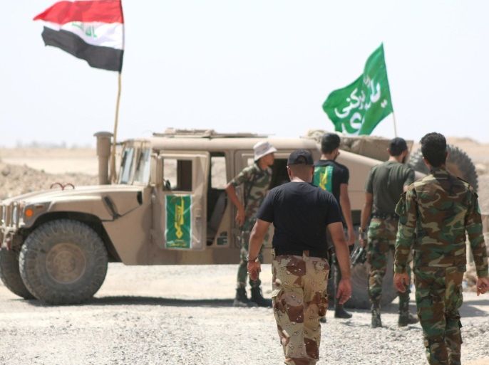 Members of the Popular Mobilisation units gather around a vehicle on the front line during a military operation against Islamic State (IS) group jihadists on the road leading to Saqlawiya, north of Fallujah, in Iraq's Anbar province on August 19, 2015. Iraqi Prime Minister Haider al-Abadi approved an investigative commission's recommendation that commanders face military justice and probable trial for withdrawing from Ramadi without orders in May. AFP PHOTO / HAIDAR MOHAMMED ALI