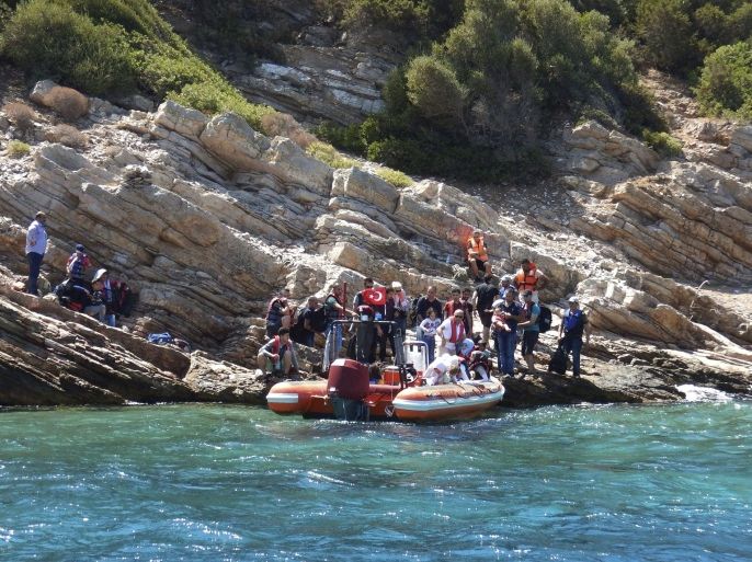 In this photo provided by the Bodrum Sea Rescue Association and taken on Monday, Aug. 17, 2015, migrants stranded on an inhabited islet are approached for rescue by members of the Bodrum Sea Rescue Association, close to the town of Bodrum, Turkey. The migrants who were trying to cross in dinghies from the Bodrum area to the nearby Greek islands, abandoned their effort and found refuge on the islet, where they had to be rescued by the Turkish Coast Guard and members of the Bodrum Sea Rescue Association. (Bodrum Sea Rescue Association via AP)