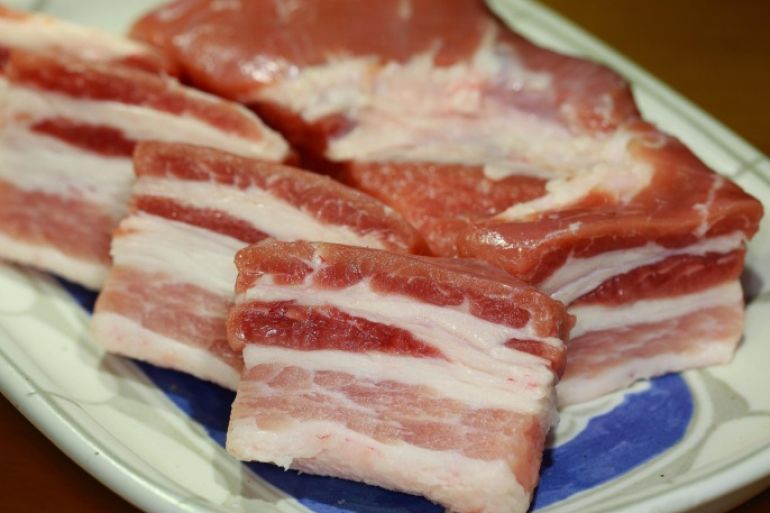 Close up of raw bacon on plate
