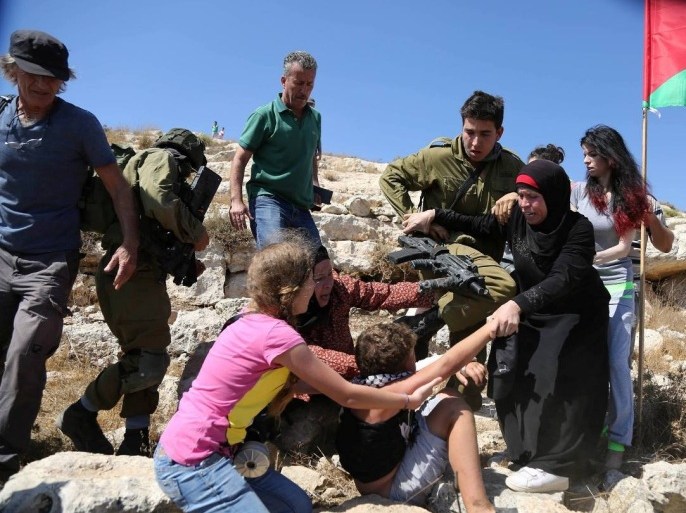 فلسطين رام الله قرية النبي صالح 28 آب 2015 نساء من عائلة التميمي يحاولن تخليص طفل من اعتقاله على يد جندي اسرائيلي
