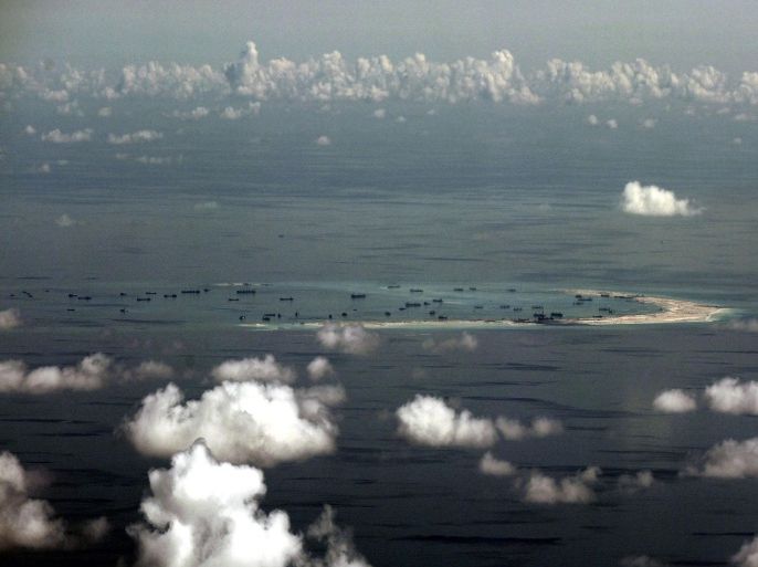 FILE -This Monday, May 11, 2015, file photo taken through a glass window of a military plane shows China's alleged on-going reclamation of Mischief Reef in the Spratly Islands in the South China Sea. As China builds artificial islands in a vast resource-rich South China Sea and neighbors in Southeast Asia brace for possible conflict, Taiwan is cutting carbon emissions and offering a hospital for humanitarian aid on the sea’s largest natural islet to seek international approval for easing tension. (Ritchie B. Tongo/Pool Photo via AP)