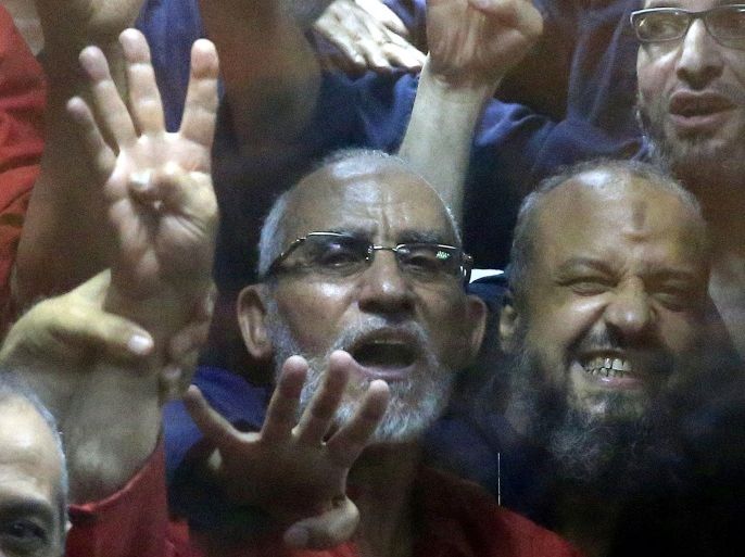 Egyptian defendants including the spiritual leader of the Muslim Brotherhood, Mohammed Badie, left, and Senior Muslim Brotherhood leader Mohammed el-Beltagy, right, make a four-fingered gesture referring to the 2013 killing of Muslim Brotherhood protesters at the Rabaah Al-Adawiya mosque, in a makeshift courtroom at the Police Academy courthouse in Cairo, Egypt, Tuesday, June 16, 2015. An Egyptian court on Tuesday confirmed a death sentence handed to ousted Egyptian President Mohammed Morsi over a mass prison break during the 2011 uprising that eventually brought him to power. The judge also confirmed death sentences for five other jailed leading members of Morsi’s Muslim Brotherhood, including Badie, the group’s leader, and Saad el-Katatni, the head of its short-lived political party. (AP Photo/Hassan Ammar)