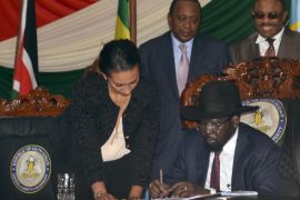 South Sudan President Salva Kiir, seated, signs a peace deal, as Kenya’s President Uhuru Kenyatta, center, and Ethiopia’s Prime Minister Hailemariam Desalegn, right, witness the signing while standing behind, in the capital Juba, South Sudan Wednesday, Aug. 26, 2015. Kiir on Wednesday signed a peace deal with rebels, more than 20 months after the start of fighting between the army and rebels led by his former deputy Riek Machar. (AP Photo/Jason Patinkin)