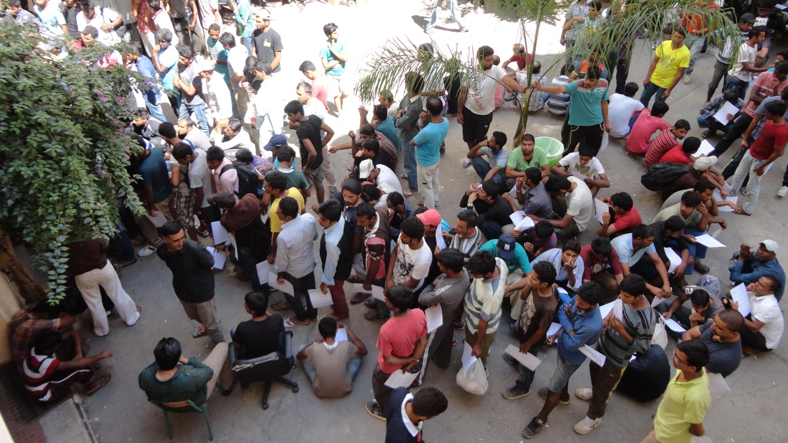 ‪‬ مهاجرون في باحة القسم ينتظرون ورقة التعريف بالهوية للسفر إلى أثينا(الجزيرة)