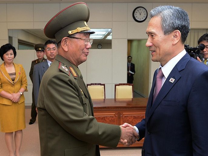 In this photo provided by the South Korean Unification Ministry, South Korean presidential security adviser Kim Kwan-jin, right, shakes hands with Hwang Pyong So, North Korea's top political officer for the Korean People's Army, after their meeting at the border village of Panmunjom in Paju, South Korea, Tuesday, Aug. 25, 2015. After 40-plus-hours of talks, North and South Korea on Tuesday pulled back from the brink with an accord that allows both sides to save face and, for the moment, avert the bloodshed they've been threatening each other with for weeks. (The South Korean Unification Ministry via AP)