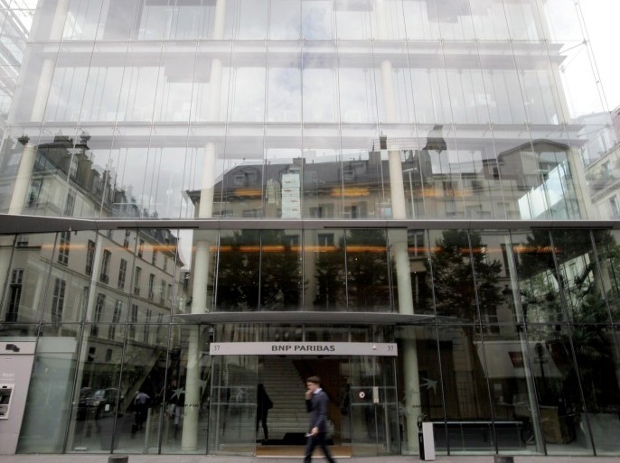Pedestrians are seen walking past a branch of BNP Paribas SA located on Place du Marche Saint-Honore, in Paris, France, on Monday, June 30, 2014. BNP Paribas won a reprieve during final talks to settle a criminal probe into U.S. sanctions violations, giving the bank six months to prepare for a ban on handling certain dollar transactions, according to a person with direct knowledge of the matter.