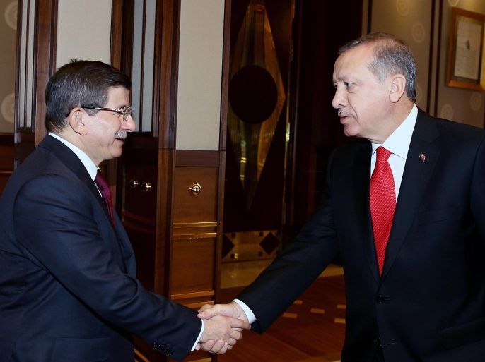 Turkey's President Recep Tayyip Erdogan, right, shakes hands with Prime Minister Ahmet Davutoglu before a meeting in Ankara, Turkey, Tuesday, Aug. 25, 2015. Erdogan on Tuesday appointed Davutoglu to form an interim government that will lead the country into a new election, likely to take place on Nov. 1. Erdogan formally called for a new election late on Monday, following an inconclusive vote in June, and the collapse of coalition-building efforts.(Presidential Press Service via AP, Pool)