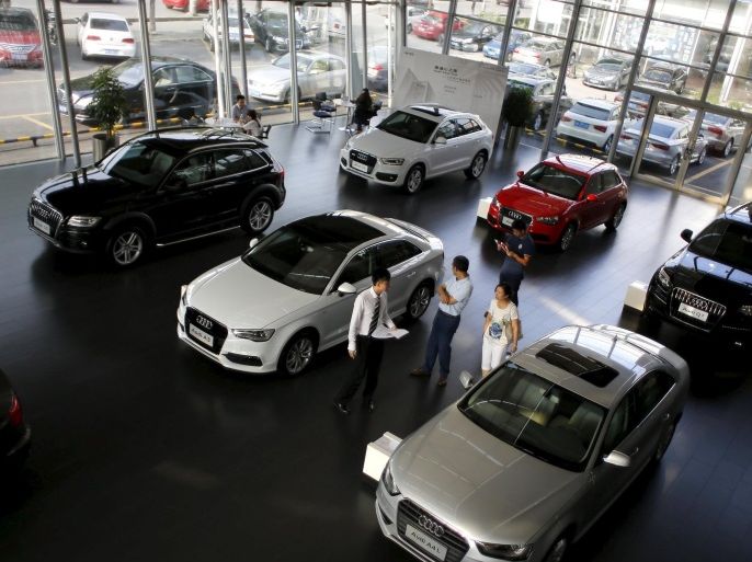 Customers look at cars at an Audi dealership from the Baoxin Auto Group in Shanghai in this September 2, 2014 file photo. The People's Bank of China on August 25, 2015 cut interest rates and reserve requirement ratios for banks by 25 basis points and further lowered reserve requirements for auto and financial leasing companies by an additional 300 basis points. The policy support is a welcome shot in the arm for the world's biggest auto sector. Sales have slowed to their weakest in at least seven years, with both domestic and foreign carmakers hit by softer demand and higher competition. REUTERS/Carlos Barria/Files