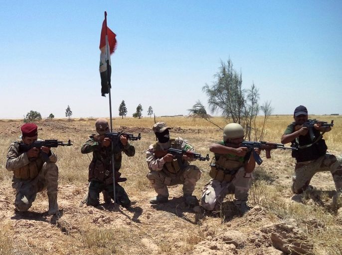 Members of the Iraqi armed forces and volunteers from a Shiite militia pose with weapons in the area around Mazra'a, south of Baiji, 400 kilometres north of Baghdad, northern Iraq, 07 July 2015. According to Iraqi officials Iraqi ground forces backed by Shiite volunteers and airstrikes carried out by the international anti-IS coalition, have made significant gains in their offensive against the group calling themselves the Islamic State (IS) around Baiji, however, clashes have continued and in some areas Iraqi forces have been pushed back according to local reports.