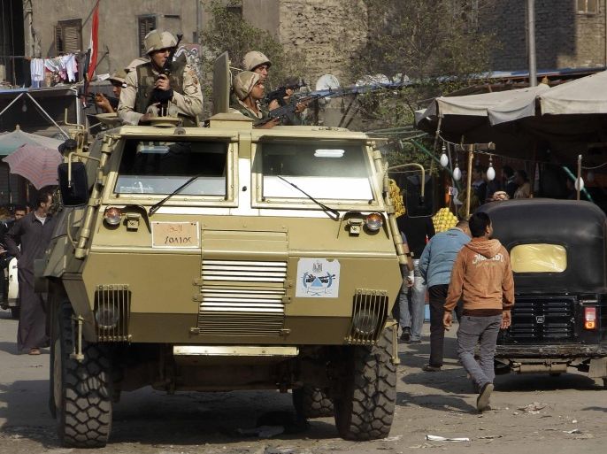 Egyptian security forces deploy in an armored vehicle in a busy market area the Cairo suburb of Matareya on the day that Islamists called for nationwide demonstrations Friday, Nov. 28, 2014. The call for rallies to topple the government and in defense of their religion is their first attempt in months to hold large protests in the face of an overwhelming crackdown since the military's ouster last year of Islamist President Mohammed Morsi.(AP Photo/Ahmed Abdel Fattah) EGYPT OUT