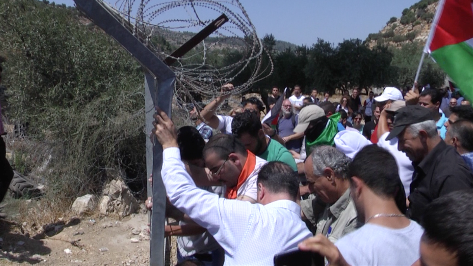 ‪فلسطينيون يقتلعون بوابات حديدية أقامها الاحتلال الإسرائيلي لمنع الأهالي من دخول أراضي بئر عونة المصادرة‬  (الجزيرة نت)