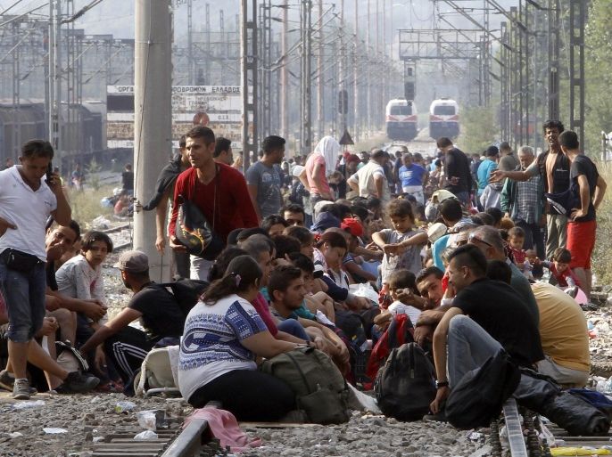 Migrants wait to enter Macedonia from Greece on the border line between the two countries, near the southern Macedonian town of Gevgelija, Wednesday, Aug. 26, 2015. Thousands of migrants have poured into Macedonia to board trains and buses taking them a step closer to the European Union. The new surge of migrants has worried EU politicians and left the impoverished Balkan countries struggling to cope with the humanitarian crisis. (AP Photo/Boris Grdanoski)