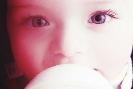 Close-Up Portrait Of Toddler Drinking Milk From Bottle