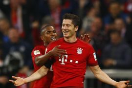 Bayern's Robert Lewandowski, right, celebrates with teammate Douglas Costa after scoring during the German Bundesliga soccer match between FC Bayern Munich and VfL Wolfsburg at the Allianz Arena stadium in Munich, Germany, Tuesday, Sept. 22, 2015. Lewandowski made Bundesliga history on Tuesday after scoring five goals in the space of nine minutes as Bayern Munich came from behind to rout Wolfsburg 5-1 and move to the top of the standings. (AP Photo/Matthias Schrader)