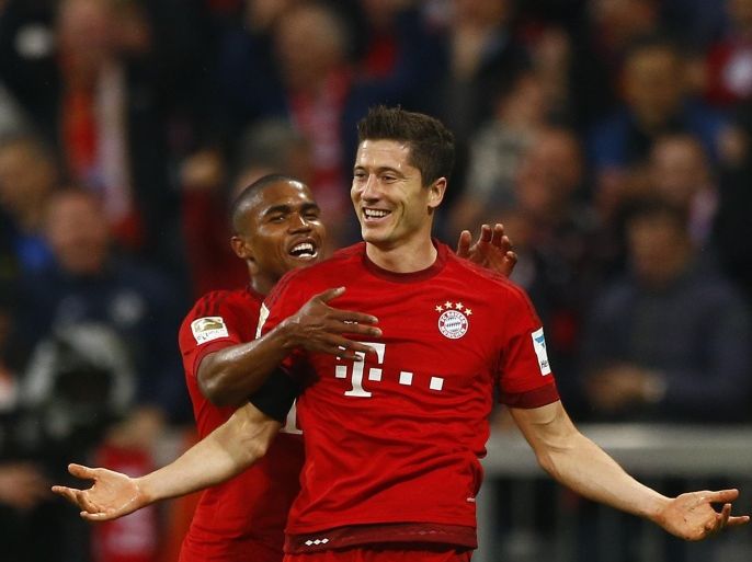 Bayern's Robert Lewandowski, right, celebrates with teammate Douglas Costa after scoring during the German Bundesliga soccer match between FC Bayern Munich and VfL Wolfsburg at the Allianz Arena stadium in Munich, Germany, Tuesday, Sept. 22, 2015. Lewandowski made Bundesliga history on Tuesday after scoring five goals in the space of nine minutes as Bayern Munich came from behind to rout Wolfsburg 5-1 and move to the top of the standings. (AP Photo/Matthias Schrader)