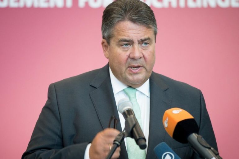 German vice chancellor Sigmar Gabriel speaks at an event to honor, volunteer helpers for refugees , in Berlin, Saturday Aug. 29, 2015. Words in background read : Commitment for Refugees. ( Kay Nietfeld/dpa via AP)
