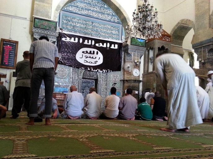 علم تنظیم الدولة الإسلامیة مرفوعا فی مسجد النوری الکبیر فی الموصل بعد سیطرة التنظیم علیها - أسوشیتدبرس