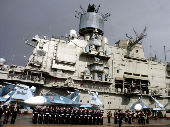 Naval personnel stand in front of the Russian aircraft carrier Kuznetsov in the Syrian city of Tartous on the Mediterranean sea January 8, 2012, in this handout photograph released by Syria's national news agency SANA.