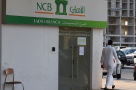 A Saudi man walks in front of a branch of the 'National Commercial Bank' (NCB) in the capital Riyadh, on October 19, 2014. Shares in National Commercial Bank went on sale Sunday in Saudi Arabia's largest-ever initial public offering, which at $6 billion is also one of the biggest in the world this year. AFP PHOTO/FAYEZ NURELDINE