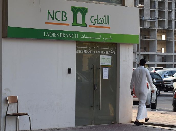 A Saudi man walks in front of a branch of the 'National Commercial Bank' (NCB) in the capital Riyadh, on October 19, 2014. Shares in National Commercial Bank went on sale Sunday in Saudi Arabia's largest-ever initial public offering, which at $6 billion is also one of the biggest in the world this year. AFP PHOTO/FAYEZ NURELDINE