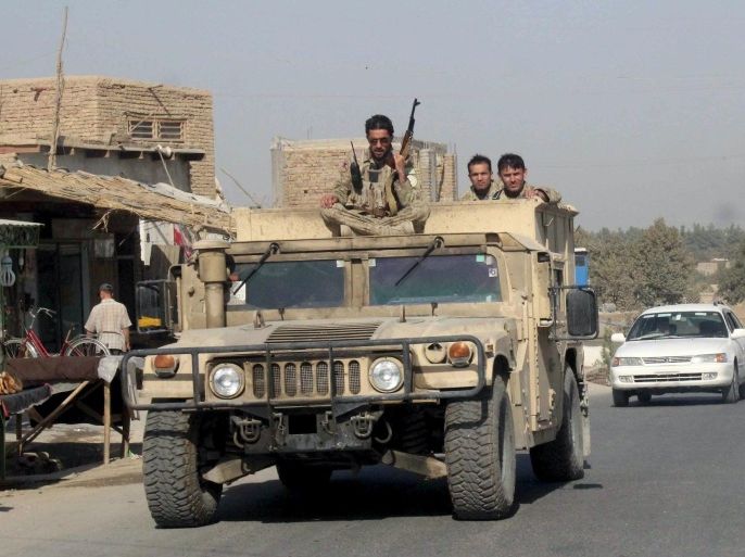 Afghan security forces travel on an armored vehicle in Kunduz Province, Afghanistan September 28, 2015. Afghan Taliban fighters who launched a three-pronged assault on the northern provincial city of Kunduz have hoisted their white banner over the main square, a Reuters witness and two security officials said on Monday. REUTERS/Stringer