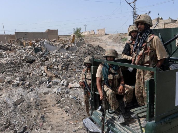 This photograph taken on July 9, 2014 shows Pakistani soldiers patrol past destroyed militants' hideouts during a military operation against Taliban militants, in the main town of Miranshah in North Waziristan. Pakistan's military says its anti-militant offensive in a northwestern tribal area has now taken control of 80 percent of a strategic town, as a US drone strike on July 10 killed six suspected insurgents. AFP PHOTO/Aamir QURESHI