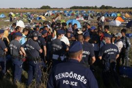 Migrants protest at a makeshift camp for asylum seekers near Roszke, southern Hungary, Wednesday, Sept. 9, 2015. Leaders of the United Nations refugee agency warned Tuesday that Hungary faces a bigger wave of 42,000 asylum seekers in the next 10 days and will need international help to provide shelter on its border, where newcomers already are complaining bitterly about being left to sleep in frigid fields. (AP Photo/Darko Vojinovic)