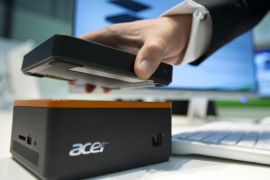 A staff member holds an external hard drive over a Revo Build modular PC at the stand of the electronic company Acer at the IFA 2015 tech fair in Berlin, Germany, Wednesday, Sept. 2, 2015. (AP Photo/Michael Sohn