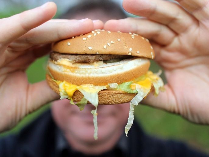 BRISTOL, ENGLAND - JANUARY 07: In this photo-illustration a man holds a burger from a fast food outlet on January 7, 2013 in Bristol, England. A government-backed TV advert - made by Aardman, the creators of Wallace and Gromit - to promote healthy eating in England, is to be shown for the first time later today. England has one of the highest rates of obesity in Europe - costing the NHS 5 billion GDP each year - with currently over 60 percent of adults and a third of 10 and 11 year olds thought to be overweight or obese.