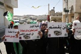 Palestinian protesters hold signs during a demonstration in the West Bank city of Hebron, Friday, Sept. 18, 2015. Israel called up a few hundred border police reservists on Friday to beef up security following Palestinian riots at Jerusalem's most sensitive holy site and outbreaks of violence elsewhere in the city that claimed the life of an Israeli and injured others this week. Arabic on the signs from right to left read, "If your are not for Quds, who will be?," "It will not be divided," "A big shout out to those holding steadfast at Aqsa Mosque." (AP Photo/ Nasser Shiyoukhi)
