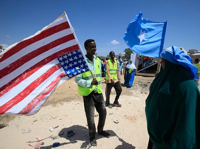 A man holds on to a American flag during a rally welcoming the announcement that the United States has officially recognized Somalia's government, after more than two decades, in Mogadishu January 21, 2013. REUTERS/Omar Faruk (SOMALIA - Tags: CIVIL UNREST POLITICS SOCIETY)