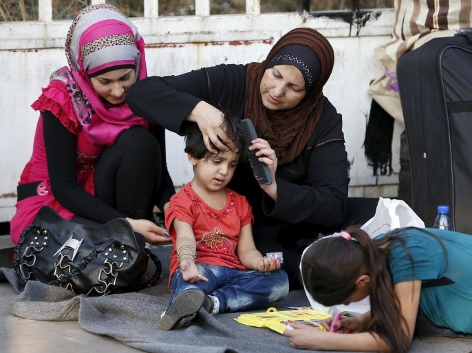 A Syrian woman combs a girl's hair as they wait at Lebanon's northern Tripoli port for a passenger ferry to Turkey, September 22, 2015. Hundreds of Syrians gather at dusk for a passenger ferry from Lebanon's northern Tripoli port to Turkey, the next step on their long trek towards what they hope will be a better, safer life in western Europe. Lebanon has long been a hub for refugees fleeing the war next door but in the past three months it has increasingly become a 24-hour transit point for mainly middle class Syrians who can afford to take the trip by road, boat and plane onwards. Picture taken September 22, 2015. REUTERS/Jamal Saidi