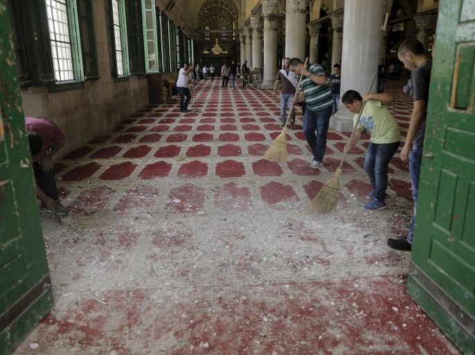 Palestinians sweep up rock debris on the carpet in Al Aqsa mosque after clashes with Israeli police on the compound known to Muslims as Noble Sanctuary and to Jews as Temple Mount in Jerusalem's Old City September 13, 2015. Israeli police raided the plaza outside Jerusalem's al-Aqsa mosque on Sunday in what they said was a bid to head off Palestinian attempts to disrupt visits by Jews and foreign tourists on the eve of the Jewish New Year. REUTERS/Ammar Awad