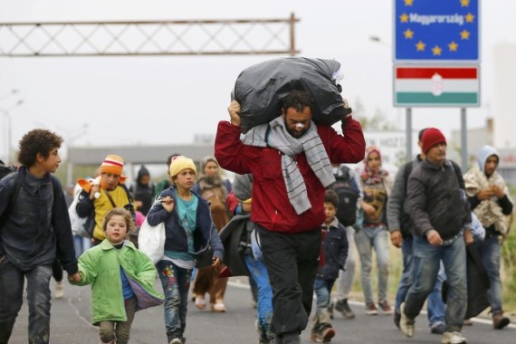 A migrant carries his belongings as he walks along with others crossing the border from Hungary into Nickelsdorf, Austria, September 25, 2015. The current flow of up to 8,000 migrants each day into Europe may only be the tip of the iceberg and governments must work to bring an end to the Syrian civil war to prevent bigger moves of people, the U.N. refugee agency said on Friday. REUTERS/Leonhard Foeger