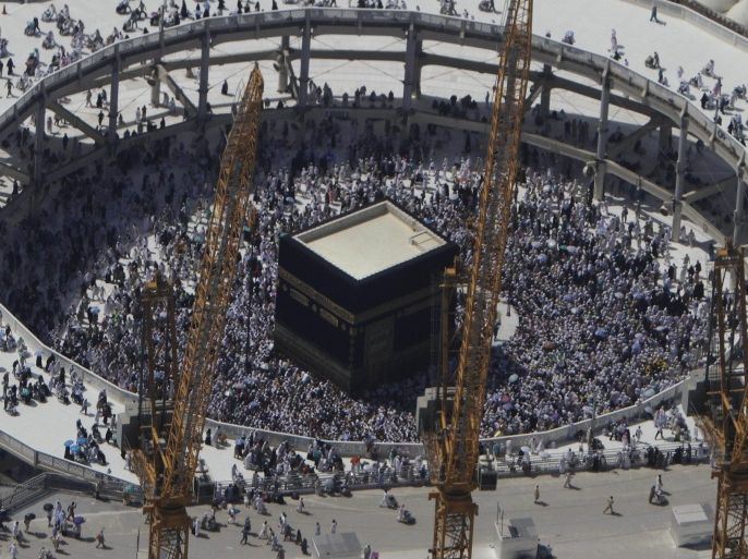FILE - In this Wednesday, Oct. 16, 2013 file photo, cranes rise at the site of an expansion to the Grand Mosque as Muslim pilgrims circle counterclockwise around the Kaaba at the Grand Mosque in Mecca, Saudi Arabia. A towering construction crane toppled over on Friday, Sept. 11, 2015 during a violent rainstorm in the Saudi city of Mecca, Islam’s holiest site, crashing into the Grand Mosque and killing dozens of people ahead of the start of the annual hajj pilgrimage later this month.(AP Photo/Amr Nabil, File)