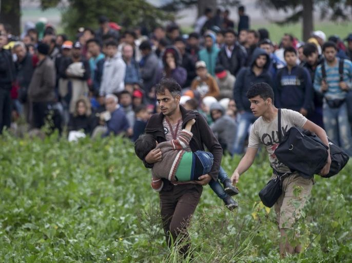 Migrants stand in a field as they wait for buses, after crossing the border from Serbia, near Tovarnik, Croatia September 24, 2015. Hungary may consider opening a "corridor" for migrants to pass through from Croatia by train or bus if Austria and Germany want one and take full responsibility, Prime Minister Viktor Orban's chief of staff said on Thursday. The route of migrants journeying northwards through the Balkans from Greece shifted to Croatia and Slovenia after Hungary sealed off its border with Serbia earlier this month. REUTERS/Marko Djurica