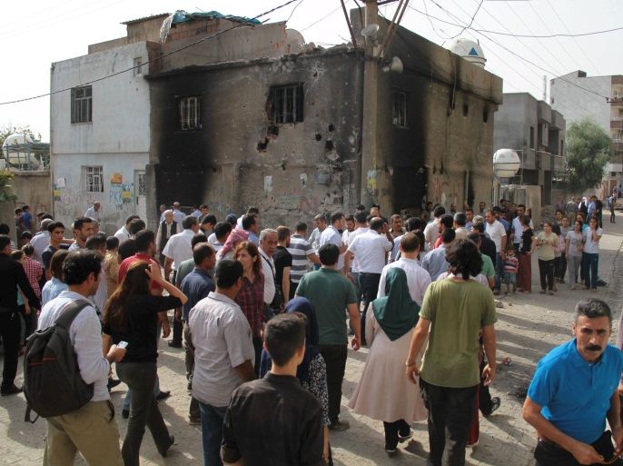 Residents and visitors walk past damaged buildings in the southeastern town of Cizre in Sirnak province, Turkey, September 12, 2015. In the town of Cizre, scene of intense clashes between the Kurdistan Workers Party (PKK) and the Turkish army, residents ventured out to stock up on groceries and check on their shops after authorities lifted a nine-day round-the-clock curfew at 7 a.m. (0400 GMT), residents said. REUTERS/Sertac Kayar