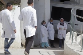 Hospital employees stand take a break outside the morgue of the Charles Nicolle hospital in Tunis Tunisia, Thursday, March 19, 2015. Authorities said more than 20 were killed after an attack on a major museum in the Tunisian capital, and some of the gunmen may have escaped. (AP Photo/Michel Euler)