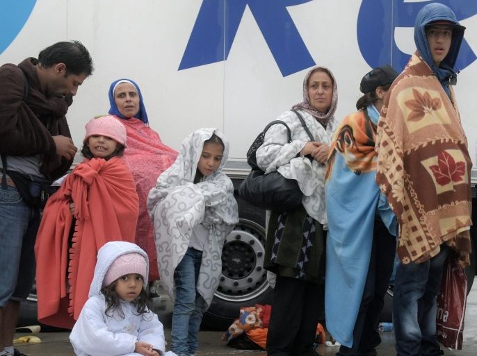 A refugee family arrives from Hungary at the border with Austria in Nickelsdorf in Burgenland 5 September 2015. The first of thousands of refugees reached Austria early 5th Sept after busloads left Hungary in a mass exodus after the Austrian and German govrnments agreed to receive them.