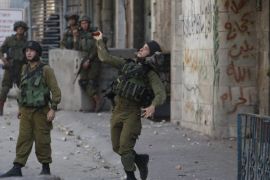 An Israeli army soldier throws a sound grenade at Palestinians during clashes following the funeral of 19-year-old Palestinian student Hadeel al-Hashlamun in the occupied West Bank city of Hebron September 23, 2015. The Israeli military said troops shot al-Hashlamun on Tuesday as she tried to stab a soldier. But relatives of al-Hashlamun denied the Israeli report saying she was executed. In a picture posted on Facebook, a soldier could be seen aiming his rifle at a woman said to be Hashlamun, standing a short distance away. She was completely covered in a black robe. REUTERS/Mussa Qawasma