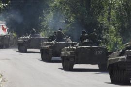 Members of the self-proclaimed Donetsk People's Republic forces ride on armoured personnel carriers (APC) near the urban settlement of Zaytsevo in Donetsk region, Ukraine, July 20, 2015. The Donetsk People's Republic (DNR) and Lugansk People's Republic (LNR) announced a unilateral three kilometers withdrawal of smaller weapons under 100mm calibre from the front line, according to local media. REUTERS/Alexander Ermochenko