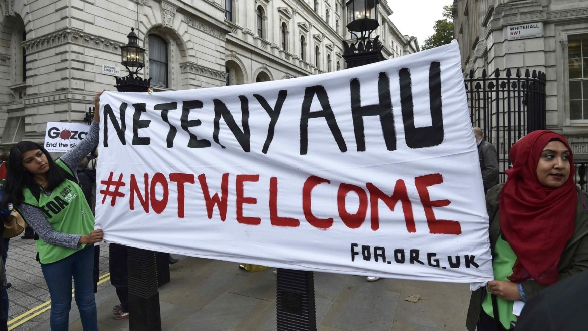 Demonstrators hold a banner that reads 'Netanyahu Not Welcome' during a protest outside Downing Street in London, Britain September 9, 2015. Pro-Israel and pro-Palestine demonstrators waved banners and scuffled during a protest ahead of a two-day visit to London by Israeli Prime Minster Benjamin Netanyahu.  REUTERS/Toby Melville